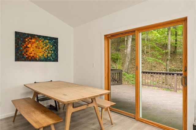 dining room with hardwood / wood-style flooring and vaulted ceiling