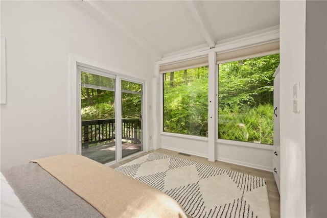 sunroom / solarium with vaulted ceiling with beams