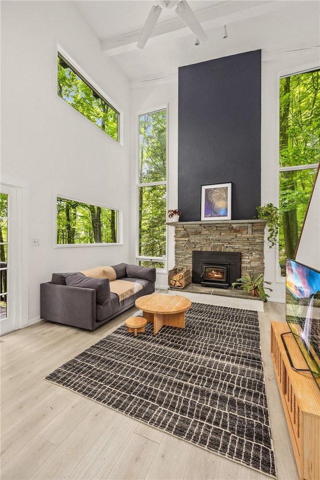 living room with beamed ceiling, ceiling fan, and light hardwood / wood-style floors