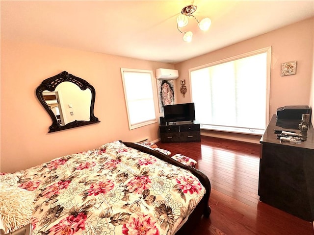 bedroom featuring a wall mounted air conditioner and dark hardwood / wood-style flooring