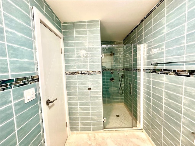 bathroom featuring a shower with door and tile walls