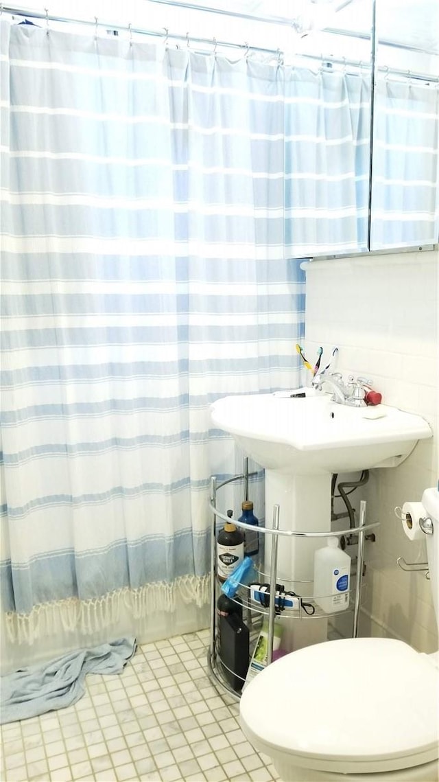 bathroom featuring tile patterned floors, shower / bath combo, and toilet