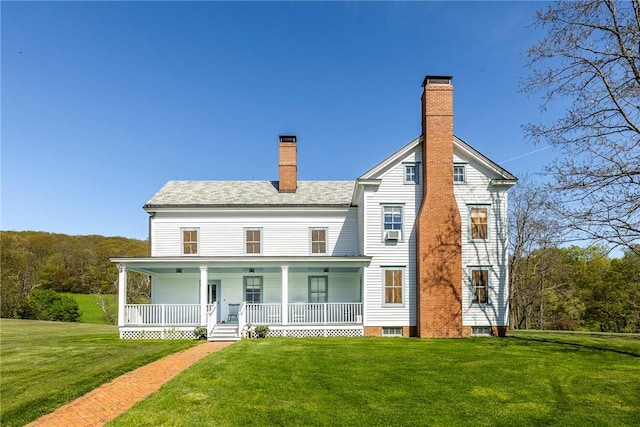 rear view of property with a lawn and a porch