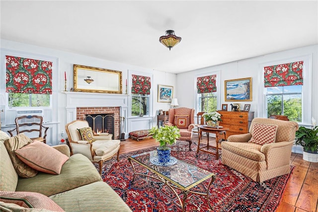 living room featuring light wood-type flooring, a fireplace, and a wealth of natural light