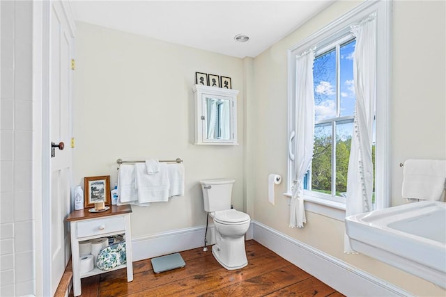 bathroom with hardwood / wood-style flooring and toilet