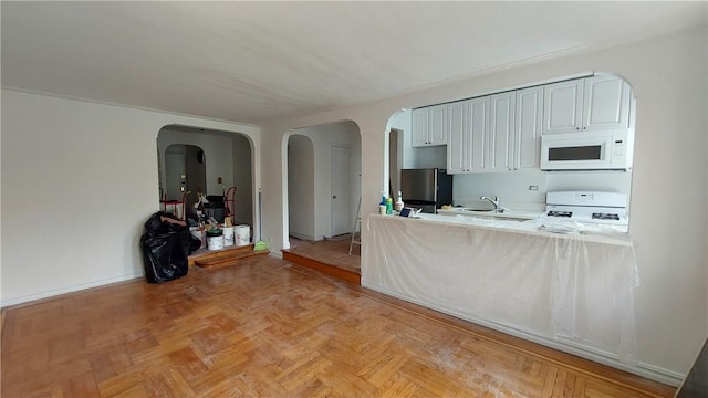 kitchen with white cabinets, white appliances, light parquet floors, and sink