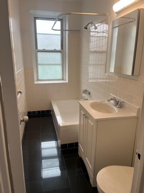 bathroom with tile patterned floors, vanity, tile walls, and toilet