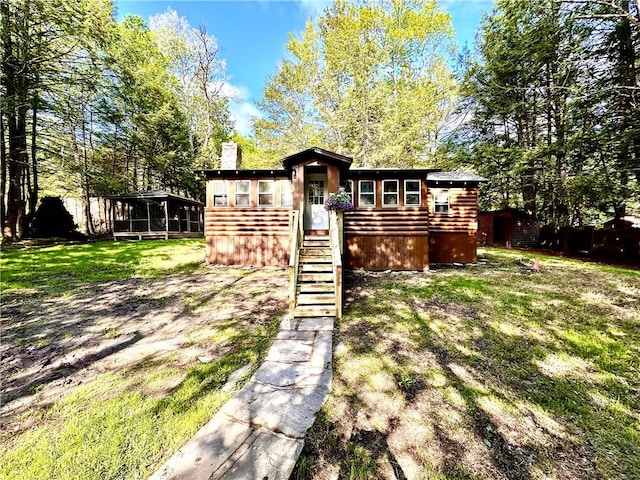 view of front of home featuring a front lawn and a sunroom