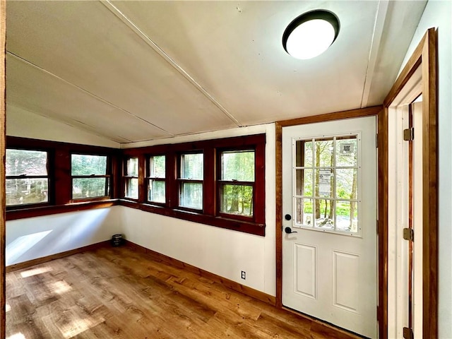 doorway with lofted ceiling and hardwood / wood-style flooring