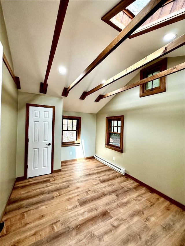 bonus room with lofted ceiling with beams, a baseboard heating unit, and light hardwood / wood-style flooring