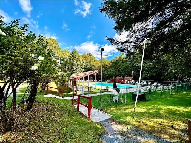 view of property's community featuring a pool and a yard