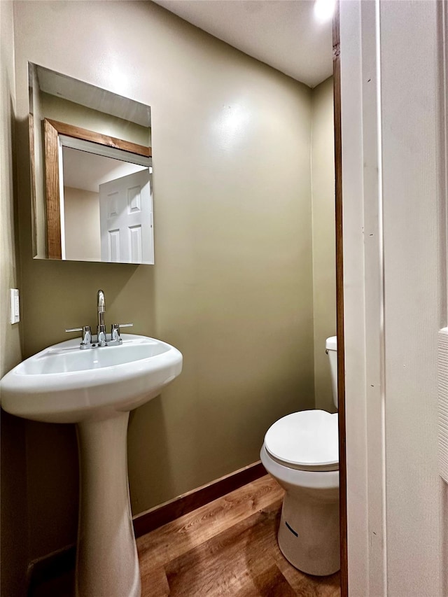 bathroom with toilet and wood-type flooring