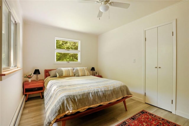 bedroom with ceiling fan, light hardwood / wood-style flooring, and a baseboard radiator