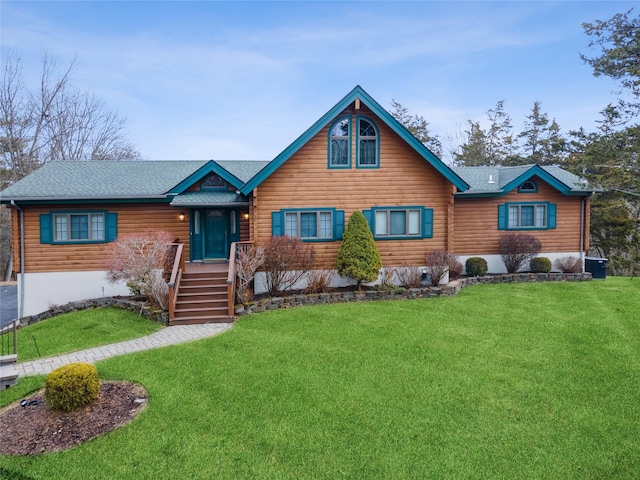 view of front of house featuring a shingled roof and a front lawn