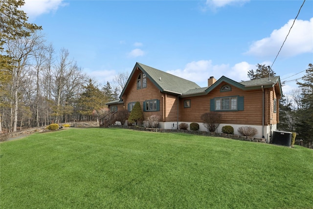 view of front of home with a front yard, central air condition unit, and a chimney