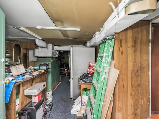 basement with dark carpet and stainless steel refrigerator