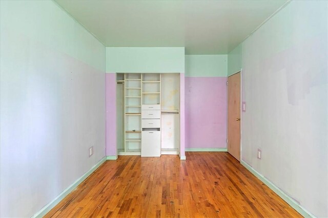 unfurnished bedroom featuring hardwood / wood-style flooring and a closet