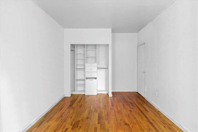 unfurnished bedroom featuring a closet and hardwood / wood-style flooring