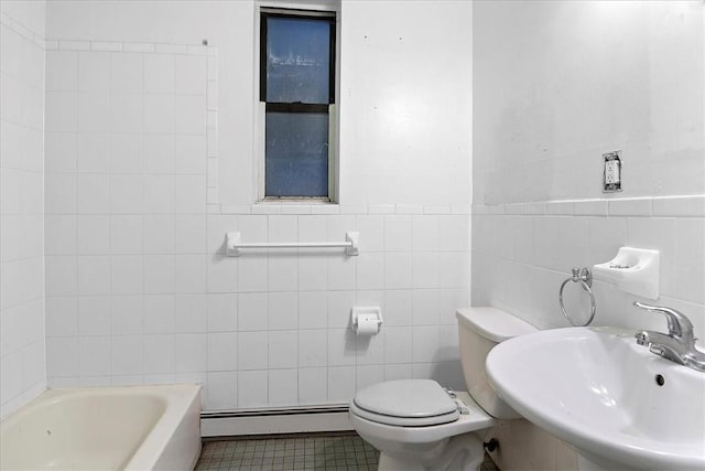 bathroom with a tub to relax in, sink, baseboard heating, and tile walls