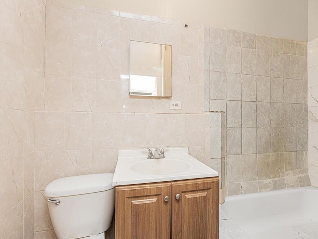 bathroom featuring vanity, tile walls, and toilet