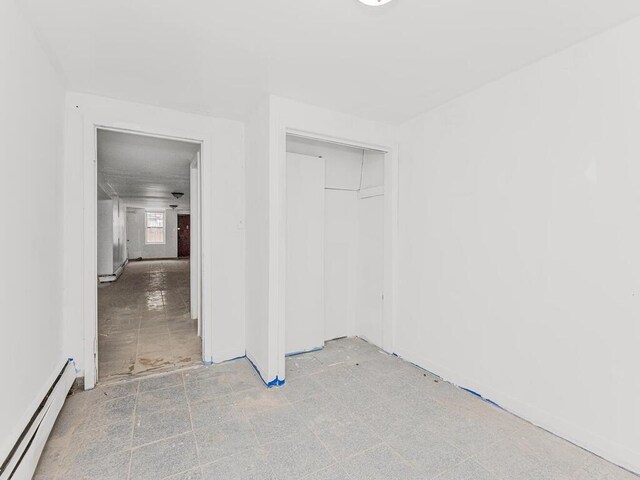 505 E 183rd St, Bronx, NY 10458 - unfurnished bedroom featuring a baseboard radiator and a closet