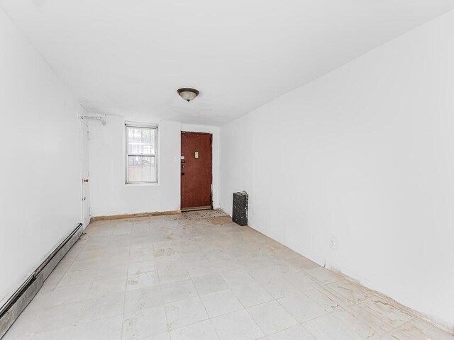 505 E 183rd St, Bronx, NY 10458 - empty room featuring a baseboard radiator and light floors