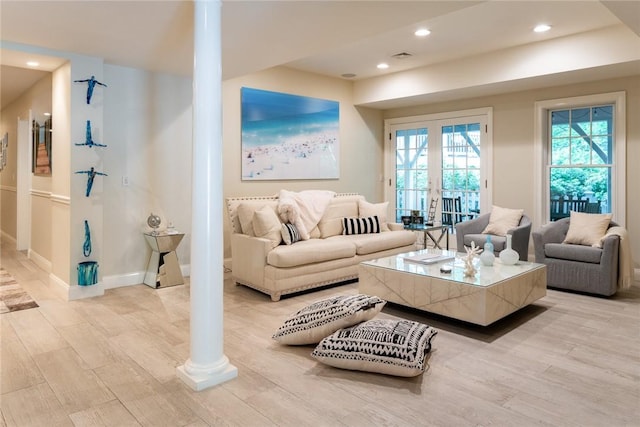 living room featuring light hardwood / wood-style floors and decorative columns