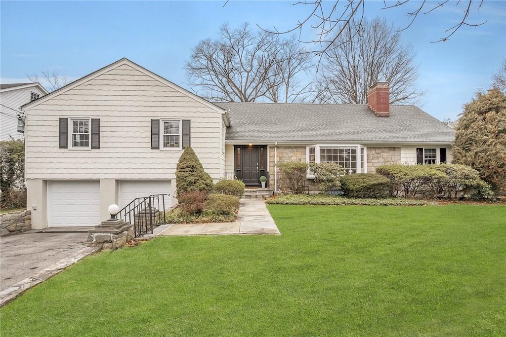 split level home featuring a front yard and a garage