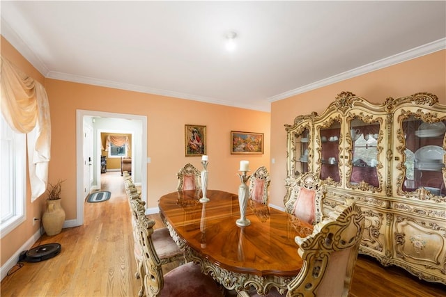 dining area with light hardwood / wood-style flooring and ornamental molding