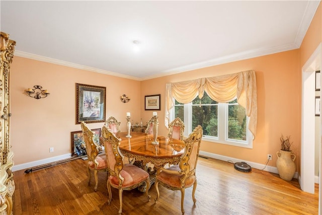 dining area featuring light hardwood / wood-style flooring and ornamental molding