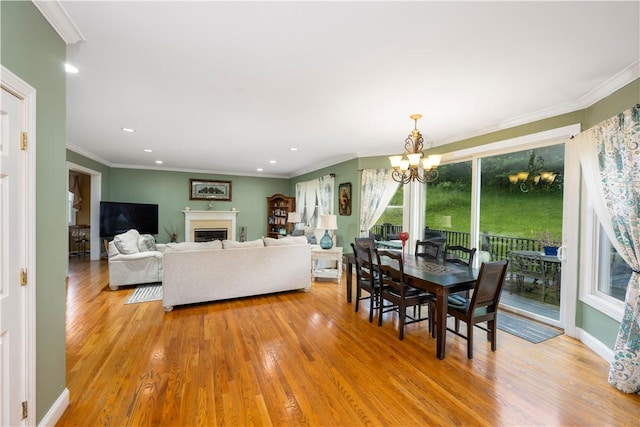 dining area with an inviting chandelier, light hardwood / wood-style flooring, and ornamental molding