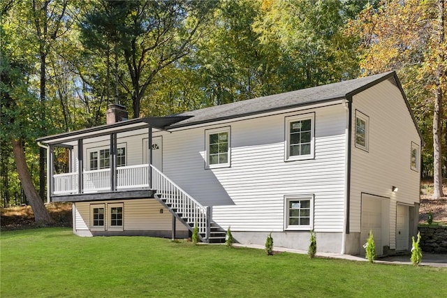 rear view of property with a garage and a yard