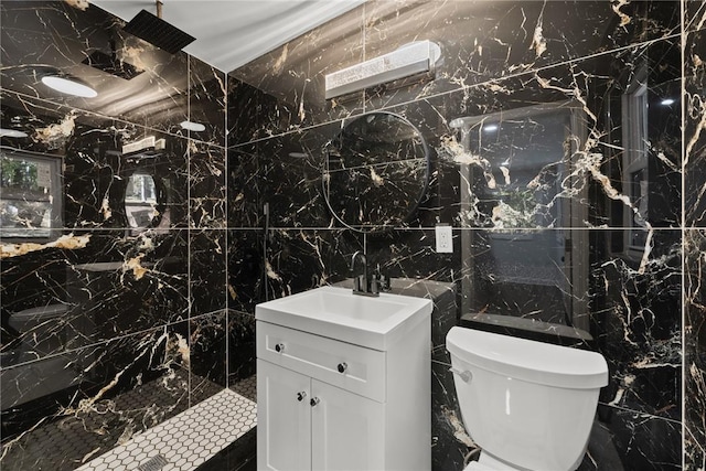 bathroom featuring walk in shower, vanity, toilet, and tile walls