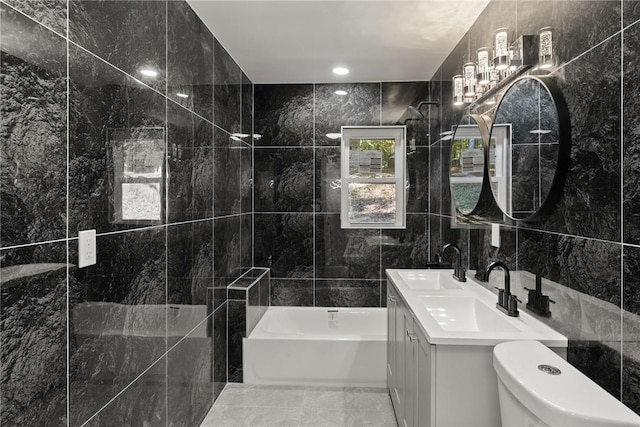 bathroom featuring vanity, toilet, tile walls, and a tub