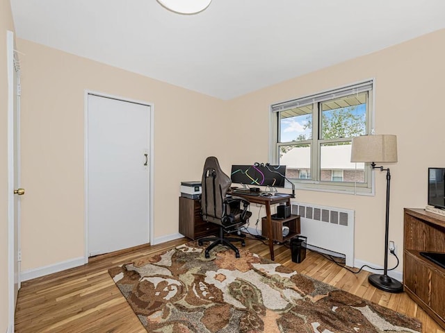 office space with light hardwood / wood-style floors and radiator