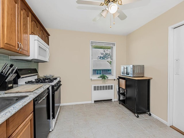 kitchen featuring ceiling fan, radiator heating unit, white appliances, decorative backsplash, and light tile patterned flooring