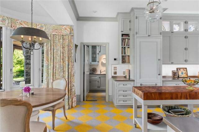 dining room featuring ornamental molding, a notable chandelier, and sink