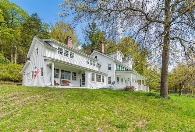 rear view of property with a patio and a lawn