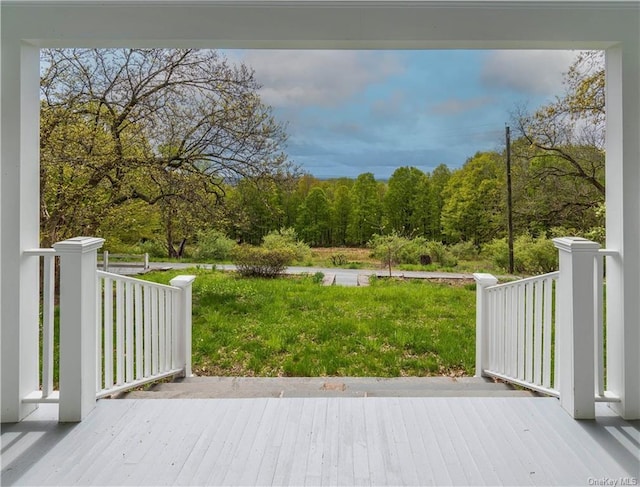 wooden deck featuring a lawn