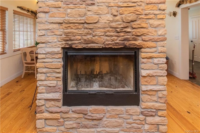 interior details featuring hardwood / wood-style flooring and a stone fireplace