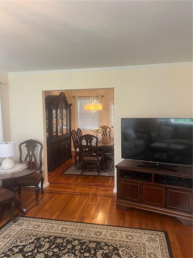 living room with hardwood / wood-style floors, a notable chandelier, and ornamental molding