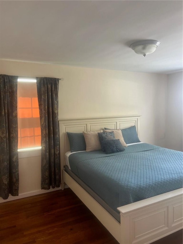 bedroom with dark wood-type flooring