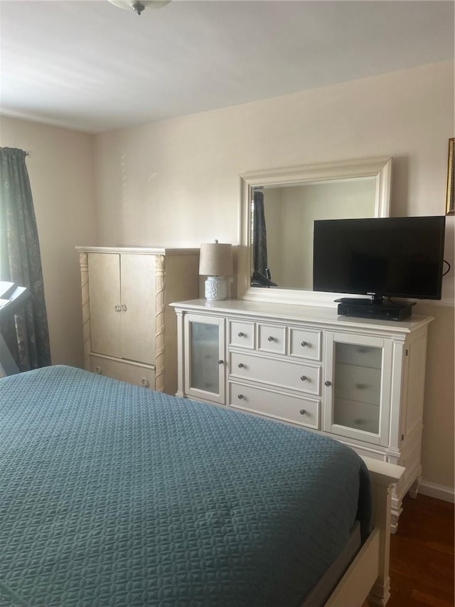 bedroom with dark hardwood / wood-style floors