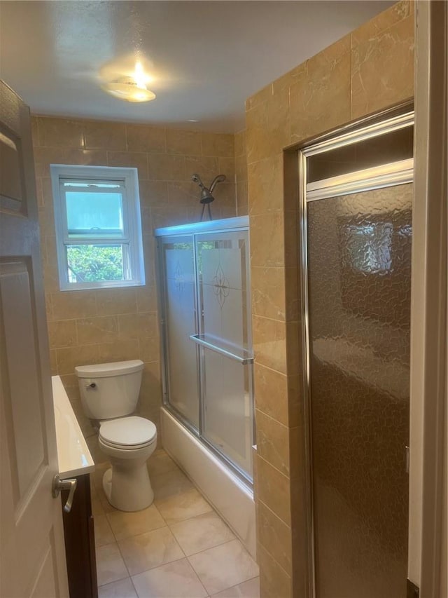 full bathroom featuring vanity, tile patterned flooring, toilet, enclosed tub / shower combo, and tile walls