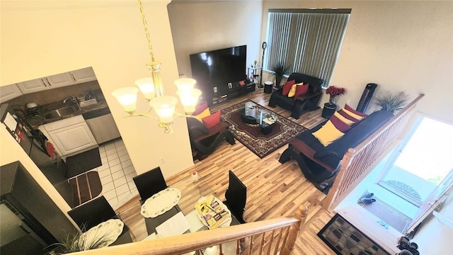 living room with a notable chandelier, wood-type flooring, and sink