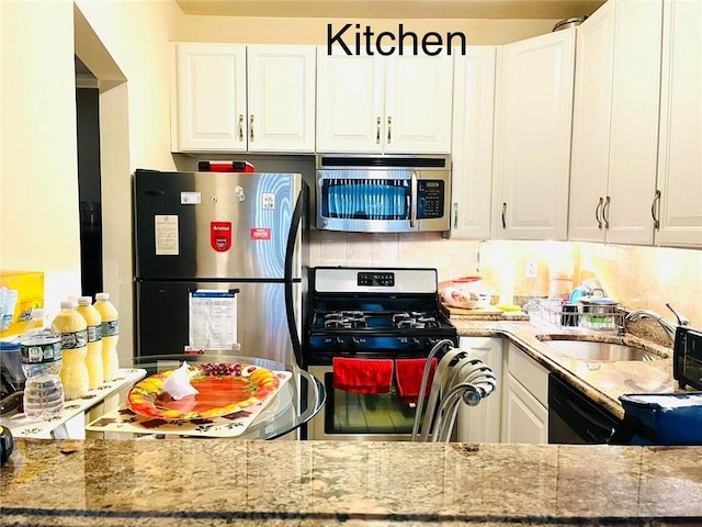 kitchen with white cabinets, decorative backsplash, sink, and stainless steel appliances