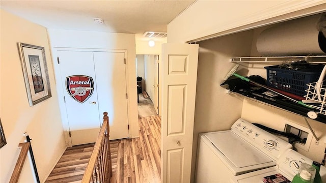 laundry area with washing machine and dryer and light hardwood / wood-style flooring