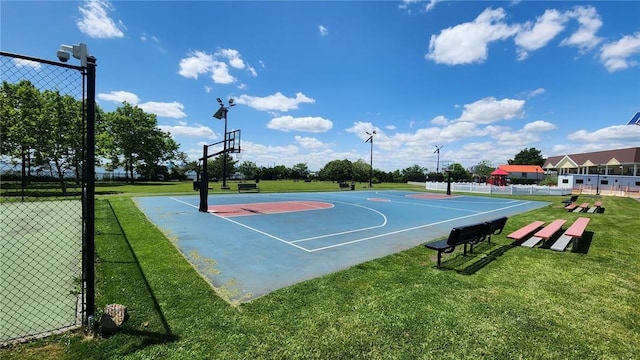 view of sport court with a lawn