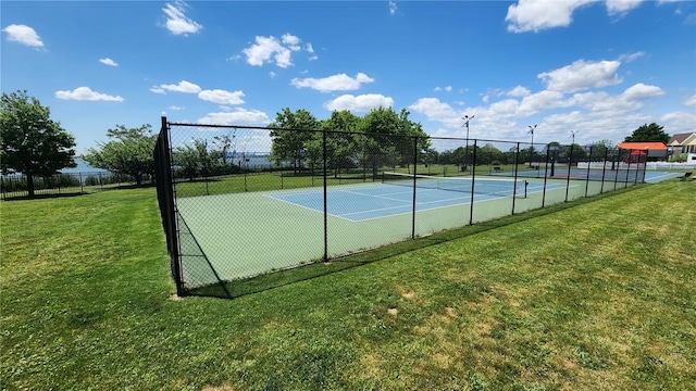 view of tennis court with a yard