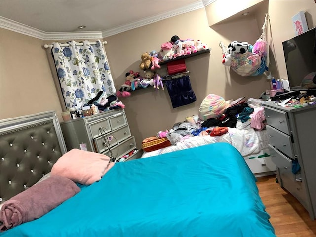 bedroom with crown molding and light hardwood / wood-style floors